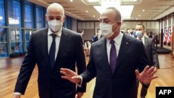 FILE - Turkish Foreign Minister Mevlut Cavusoglu (R) speaks with Greek Foreign Minister Nikos Dendias as they arrive to the press conference following their meeting in Ankara, Apr. 15, 2021. 