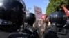 FILE - Protesters confront riot police during an anti-government rally along Habib Bourguiba avenue in Tunisia's capital Tunis, Oct. 10, 2021.