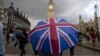 A pedestrian shelters from the rain beneath a Union Jack-themed umbrella near the Big Ben clock face and the Elizabeth Tower at the Houses of Parliament in central London, following the pro-Brexit result of the UK's EU referendum vote, June 25, 2016.
