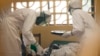 In this 2014 photo provided by the Samaritan's Purse aid organization, Dr. Kent Brantly, left, treats an Ebola patient at the Samaritan's Purse Ebola Case Management Center in Monrovia, Liberia.