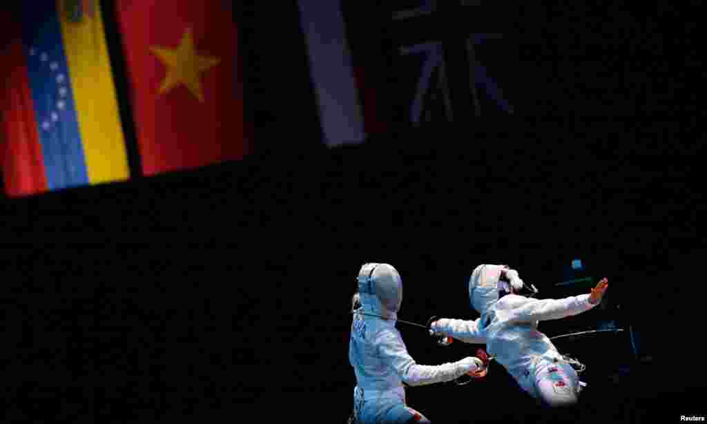 Poland's Aleksandra Socha (R) competes against Canada's Sandra Sassine during their women's sabre individual round of 32 fencing competition at the ExCel venue.
