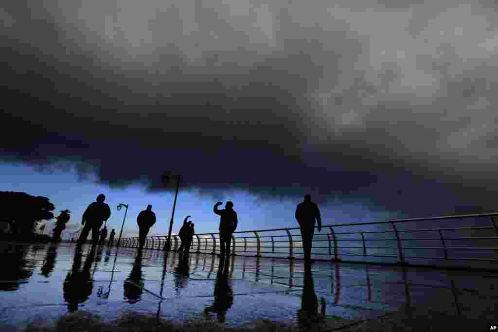 People take 'selfies' on the seafront at the Corniche, or waterfront promenade, in Beirut, Lebanon.