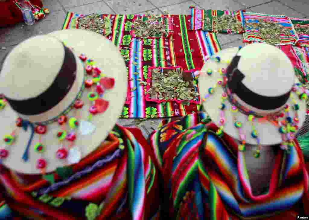 Bolivian indigenous women sit in front of coca leaves during a ceremony that marks 10 years of President Evo Morales&#39; administration in La Paz. Morales delivered his State of the Nation address at the National Congress.