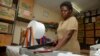 FILE - A worker cuts locally made biodegradable sanitary pads known as Makapads, made from waste paper with papyrus as the absorbent, that sell for half the price of imported pads, at the factory in Kampala, Uganda. 