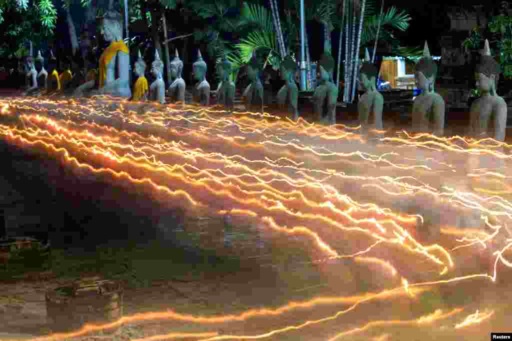 Buddhists carry candles as they pray during Vesak Day, an annual celebration of Buddha's birth, at Wat Yai Chai Mongkhon temple in Ayutthaya, Thailand.