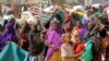 FILE - People fleeing from drought in the Lower and Middle Shabelle regions of Somalia carry their belongings as they reach a makeshift camp for displaced persons in the Daynile neighborhood on the outskirts of the capital Mogadishu, May 18, 2019.