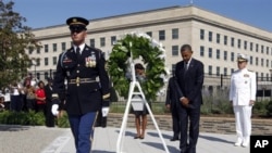 သမ္မတ Barack Obama နဲ့ သမ္မတကတော် Michelle Obama တို့ ပန်တဂွန် စစ်ဌာနချုပ်မှာ ကျင်းပတဲ့ စက်တင်ဘာ ၁၁ အကြမ်းဖက်တိုက်ခိုက်မှု အောင်းမေ့ဘွယ် အခမ်းအနားမှာ ပန်းခွေချ အလေးပြုနေစဉ်၊ (ဓာတ်ပ၊ုံ အေပီ၊စက်တင်ဘာ ၁၁၊ ၂၀၁၁)