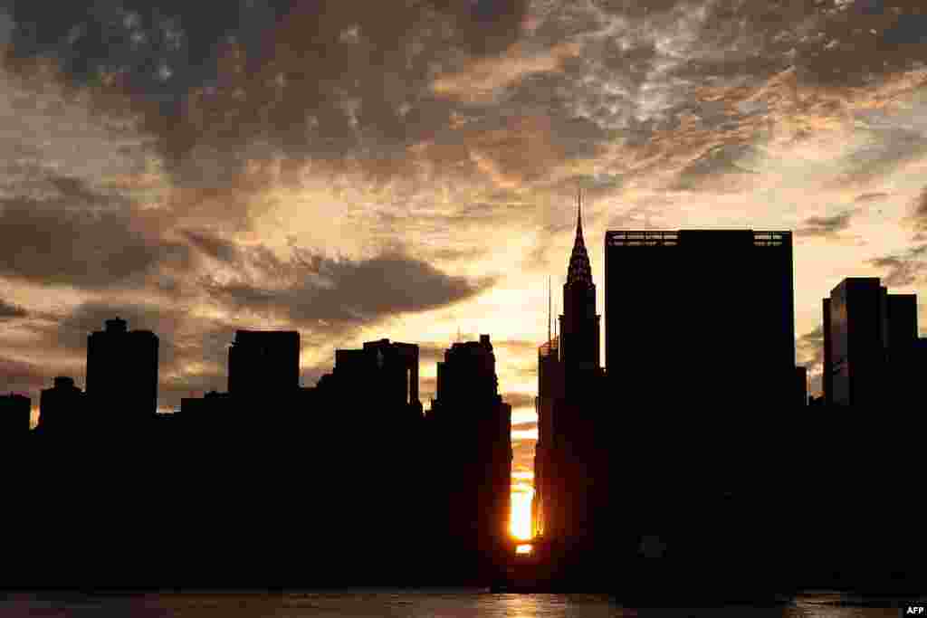 Pemandangan matahari terbenam di Manhattan, New York yang dikenal sebagai &#39;Manhattanhenge&#39; dari Hunters Point South Park, &nbsp;di Queens borough, New York.