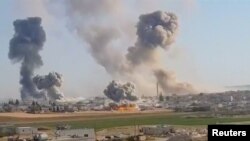 Plumes of smoke rise from a location, said to be Khan al Subul, Idlib province, Syria, following an airstrike, in this still image taken from a video uploaded May 28, 2019.