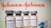FILE - Vials with a sticker reading, "COVID-19 / Coronavirus vaccine / Injection only" and a medical syringe are seen in front of a displayed Johnson & Johnson logo in this illustration, Oct. 31, 2020. 