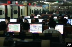 FILE - Customers surf the web at an internet cafe in Beijing, China.