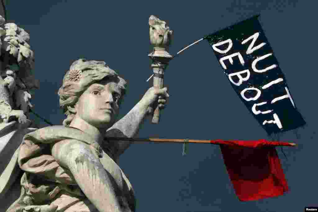 A red flag and a black one reading &quot;Nuit Debout&quot; (Rise Up at Night) are seen on the Place de la Republique in Paris, France, during a social media-driven movement against a labor law proposal.