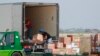 Workers unload a cargo plane carrying medical aid at the Baghdad Airport in Iraq, Monday, April 20, 2020.