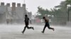 Men run for cover during a heavy rain shower in the northern Indian hill town of Shimla, July 4, 2014.