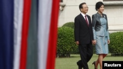 Chinese Premier Wen Jiabao (L) walks with Thai Prime Minister Yingluck Shinawatra during a welcoming ceremony at the Government House in Bangkok, November 21, 2012.