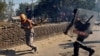 A policeman chases away a farmer during a protest against the newly passed farm bills at Singhu border near Delhi, India, Nov. 27, 2020.