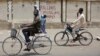 Two boys ride their bicycles past a sign reading "Stop killing Muslims Army" on a wall in Kano, Nigeria, April 8, 2016. Nigeria's Kaduna state government has secretly buried hundreds of minority Shi'ite Muslims in a mass grave.