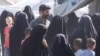 زنان در کمپ الهول گرد خبرنگار صدای امریکا جمع شده و از انتقال کودکان شان به مراکز افراطگرایی شکایت دارند