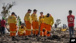 FILE - Investigators from Israel examine wreckage on March 12, 2019, at the scene of the Ethiopian Airlines Boeing 737 Max 8 crash near Bishoftu, or Debre Zeit, south of Addis Ababa, in Ethiopia.