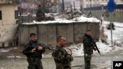 National army soldiers stand guard at the site of suicide attack near the military academy in Kabul, Afghanistan, Tuesday, Feb. 11, 2020.