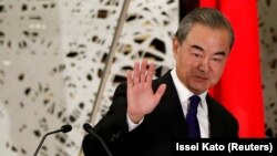 Menteri Luar Negeri China Wang Yi melambaikan tangan kepada para awak media seusai melaksanakan konferensi pers di Tokyo, Jepang, pada 24 November 2020. (Foto: Reuters/Issei Kato/Pool)