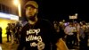 A man is moved by a line of police as authorities disperse a protest in Ferguson, Mo., Aug. 20, 2014.