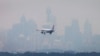 FILE - An Australian commercial aircraft prepares to land in the haze at Sydney's International Airport, July 15, 2014. 