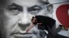 A woman takes part in a protest against Israeli Prime Minister Benjamin Netanyahu, seen on the poster, in Tel Aviv, Israel, April 19, 2020.