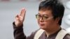 FILE - Arnon Nampa, a prominent activist and former human rights lawyer, flashes a three-finger salute as he arrives ahead of a Thai criminal court's verdict in a case of allegedly having insulted the monarchy, at the criminal court in Bangkok, Thailand, Sept. 26, 2023. 