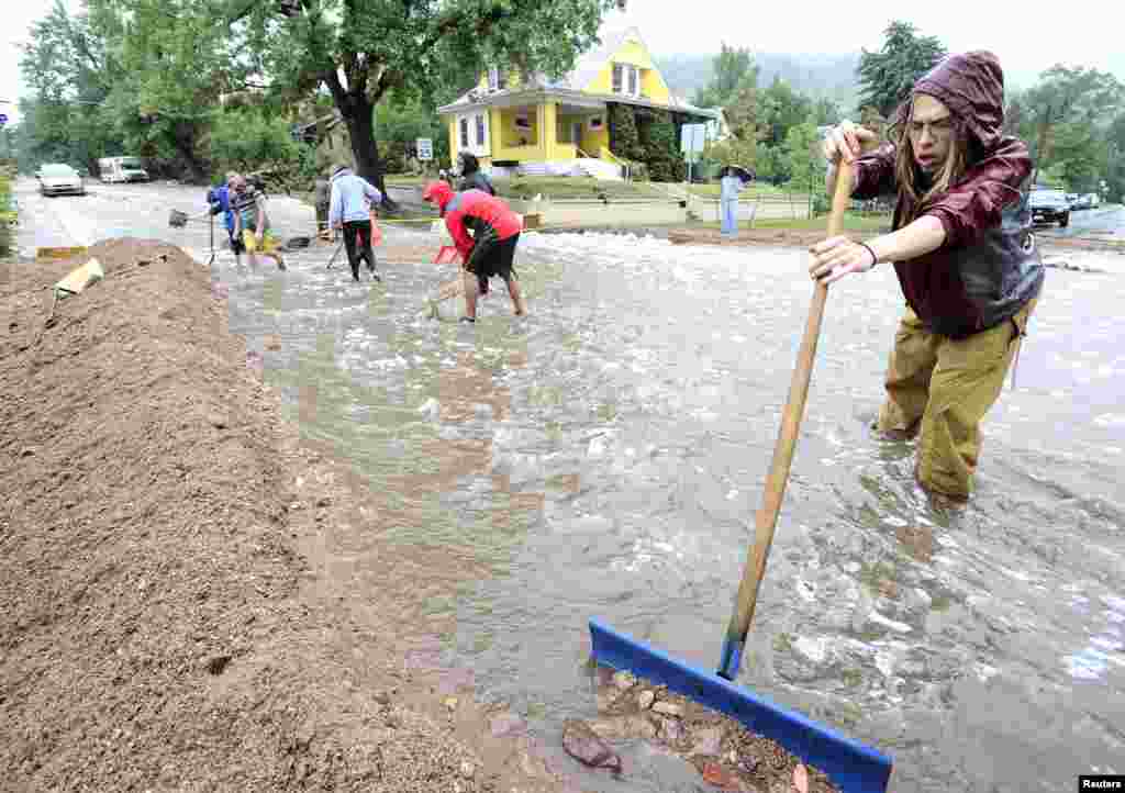 Nick Carter shovels debris as heavy rains cause severe flooding in Boulder, Colorado, Sept. 12, 2013. 