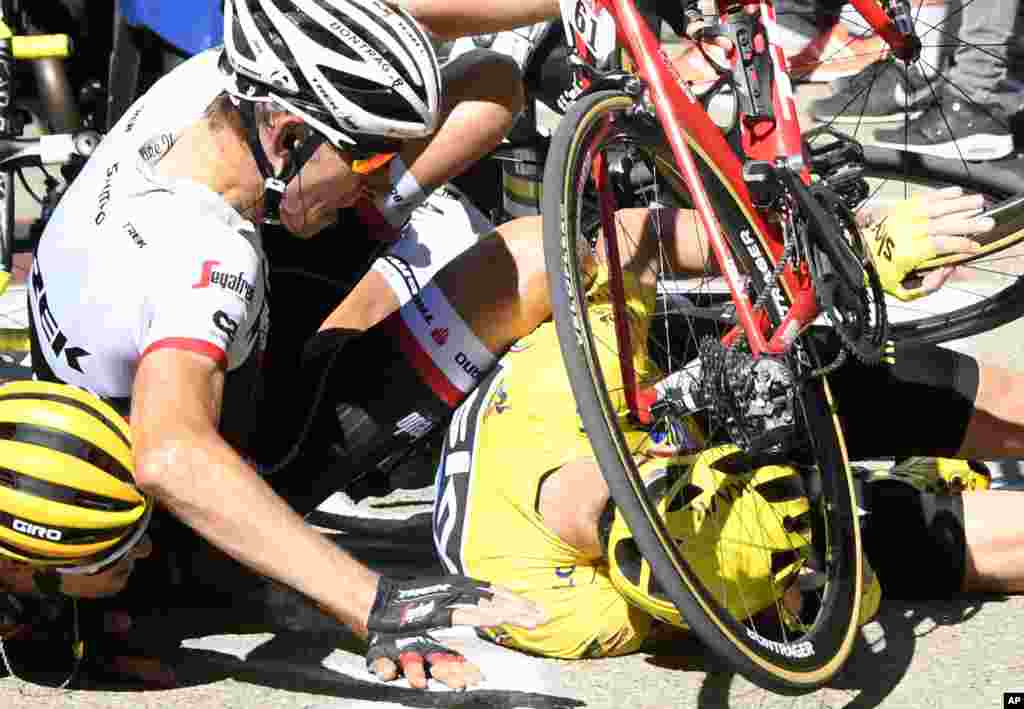 Britain's Chris Froome, wearing the overall leader's yellow jersey, right, Netherlands’ Bauke Mollema, center, and Australia’s Richie Porte, crash at the end of the twelfth stage of the Tour de France cycling race. It started in Montpellier and finishes in Mont Ventoux, France.