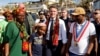 Presiden Prancis Emmanuel Macron (tengah) berjalan bersama sejumlah warga lokal saat berkunjung ke distrik kavani di Mamoudzou, Mayotte, pada 19 Desember 2024, menyusul topan yang memporak-porandakan wilayah tersebut. (Foto: Ludovic Marin/Pool/AFP)