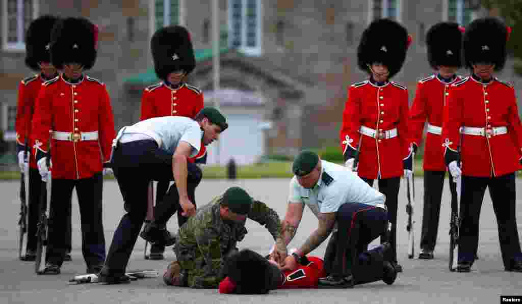 Seorang anggota pasukan kehormatan Kanada pingsan dalam upacara penyambutan Presiden Meksiko di Citadelle, Quebec City, Kanada.