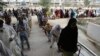 People wait to receive cash under the government's Ehsaas Emergency Cash Program for families in need during a government-imposed nationwide lockdown to help contain the spread of the coronavirus, in Karachi, Pakistan, April 14, 2020.