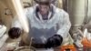 FILE - Microbiologist Ruth Bryan works with BG nerve agent simulant in Class III Glove Box in the Life Sciences Test Facility at Dugway Proving Ground, Utah, May 11, 2003.
