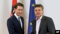 Sebastian Kurz, left, head of the Austrian People's Party, OEVP, shakes hands with Werner Kogler, right, head of the Austrian Greens during a press conference after finishing the coalition negotiations in Vienna, Austria, Jan. 1, 2020.