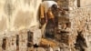 FILE - A low-caste sweeper cleans excreta flowing out of a public toilet at Ajmer, India.