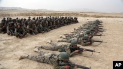 FILE - Afghan National Army soldiers carry out an exercise during a live firing at the Afghan Military Academy in Kabul, Afghanistan, Oct. 31, 2018.