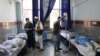 Afghan men receive treatment at a hospital after a bus was hit by a roadside bomb in Herat province, western Afghanistan, July 31, 2019. 