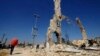 A picture of Syria's President Bashar al-Assad is displayed on a damaged structure at the entrance of al-Dukhaneya neighborhood near Damascus, October 7, 2014