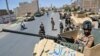 FILE - Afghan National Army commando forces stand guard along a road amid ongoing fighting between Taliban and Afghan security forces in the Enjil district of Herat province, August 1, 2021.