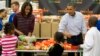 President Barack Obama, right, and first lady Michelle Obama participate in a Thanksgiving service project by handing out food at the Capital Area Food Bank in Washington, Nov. 27, 2013.