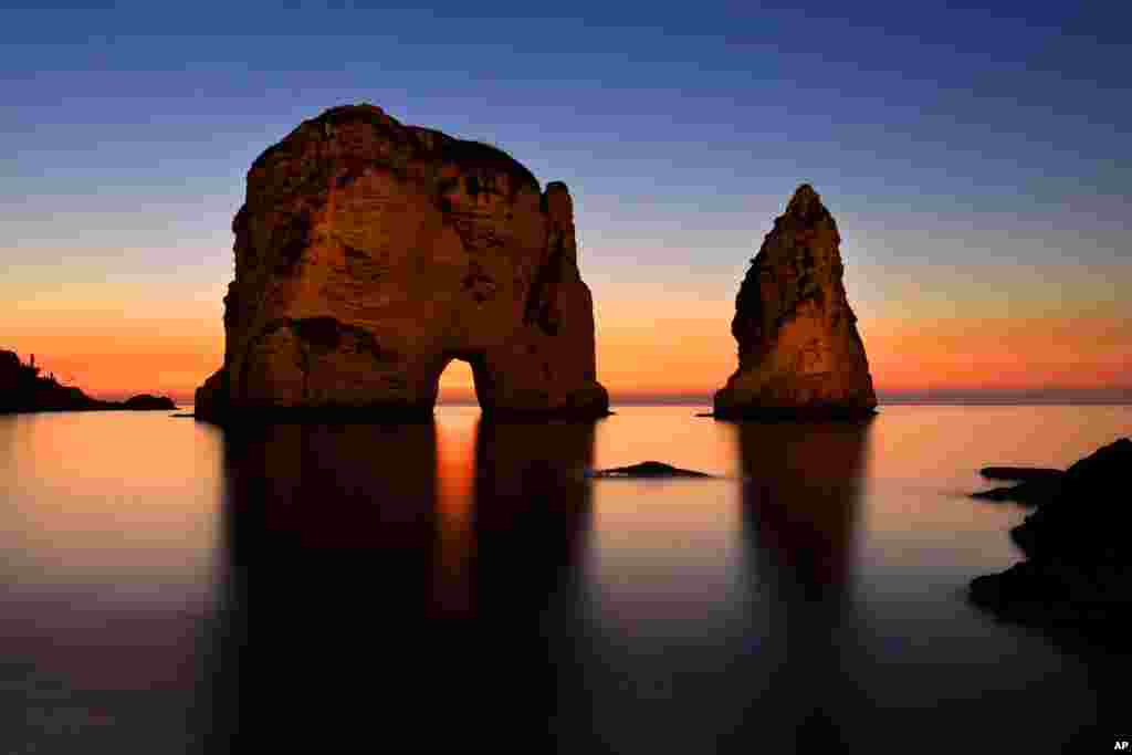 The sun sets over the Mediterranean Sea as seen at the Rawcheh Sea Rock in Beirut, Lebanon.