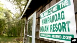 FILE — A poster declaring support for bringing a casino to Middleborough, Mass., appears on the side of a small house on property adjacent to land belonging to the Mashpee Wampanoag tribe.