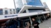 FILE - A TV correspondent reports in front of Halkbank headquarters in Atasehir, in the Asian part of Istanbul.