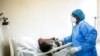 FILE - A doctor uses a stethoscope to listen to the breathing of a patient confirmed to have COVID-19 at the Fann university hospital in Dakar, Senegal, May 13, 2020.