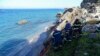 Petugas SAR menarik jenazah seorang migran dari pantai setelah kapal karam di Pulau Rhodes, Yunani tenggara, Senin, 23 November 2020. (Foto: via AP)
