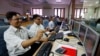 FILE - Indian stockbrokers celebrate as they watch the Bombay Stock Exchange (BSE) index on their trading terminal in Mumbai, India.