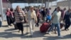 Palestinians with dual citizenship walk at the Rafah border crossing with Egypt, in the hope of getting permission to leave Gaza