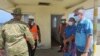 New Zealand High Commissioner Peter Lund, right, and military personnel stand on a dock in Nuku'alofa, Tonga, Jan. 21, 2022 after receiving a New Zealand ship that brought provisions.
